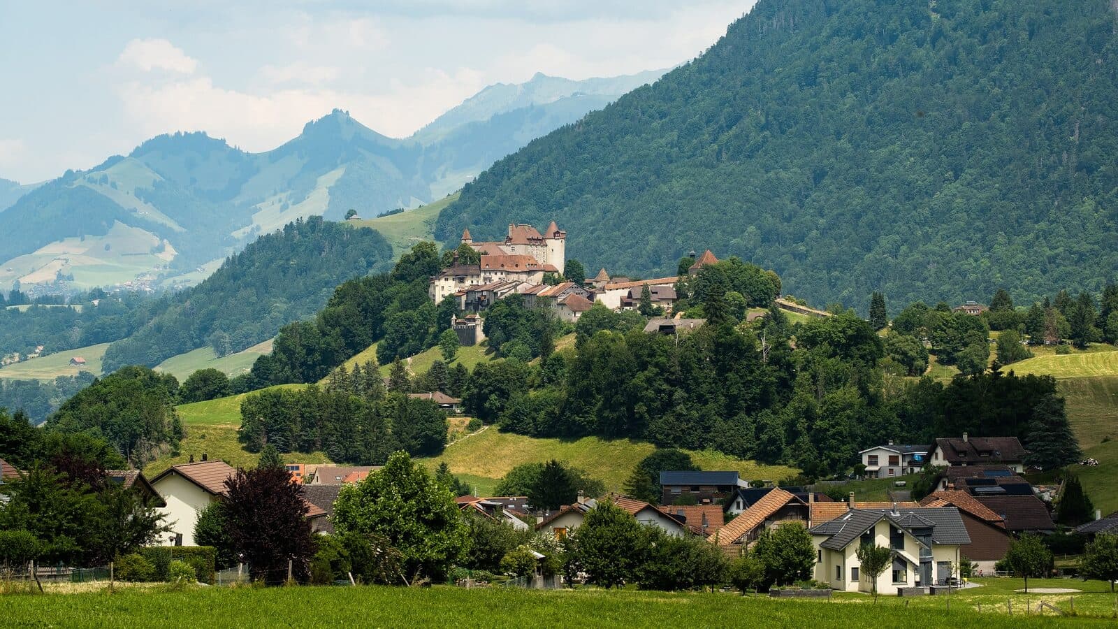 The medieval town of Gruyères on its hill, surrounded by green pastures and Pre-Alps